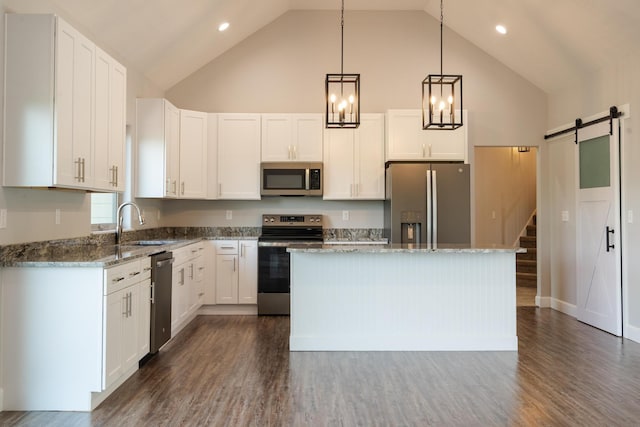 653 Forest Lake Dr, Branson West, MO 65737 - kitchen featuring appliances with stainless steel finishes, a barn door, high vaulted ceiling, a kitchen island, and a sink