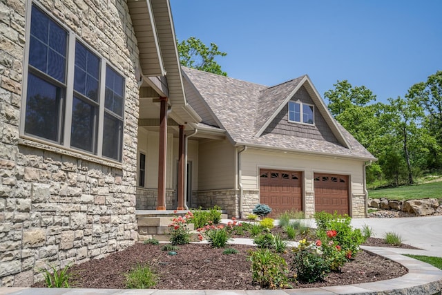 653 Forest Lake Dr, Branson West, MO 65737 - view of exterior entry featuring stone siding, a shingled roof, a garage, and concrete driveway