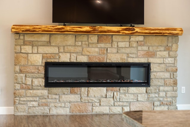 653 Forest Lake Dr, Branson West, MO 65737 - detailed view of baseboards, a glass covered fireplace, and wood finished floors
