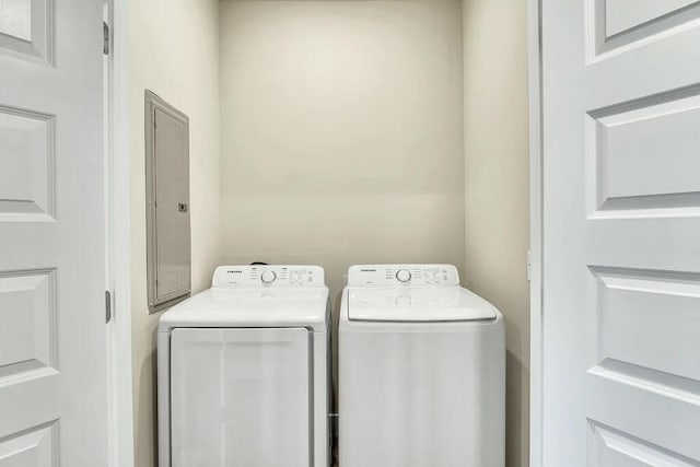 washroom featuring electric panel and washing machine and clothes dryer