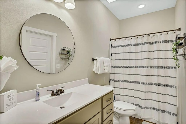 bathroom featuring walk in shower, vanity, and toilet