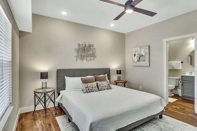 bedroom featuring ceiling fan, dark wood-type flooring, and connected bathroom