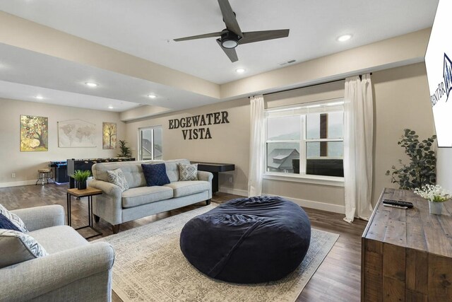 living room with ceiling fan and dark hardwood / wood-style flooring