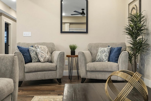 living area featuring ceiling fan and dark hardwood / wood-style flooring