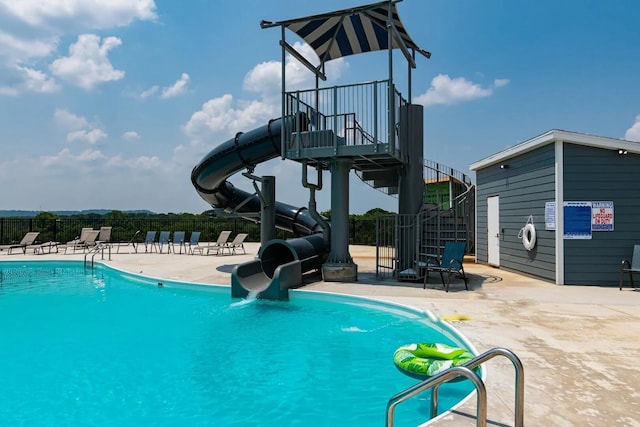 view of swimming pool with a patio and a water slide