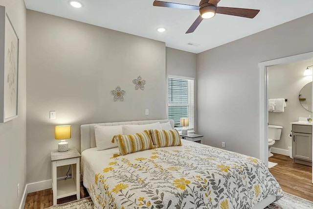 bedroom with ensuite bathroom, ceiling fan, and hardwood / wood-style flooring