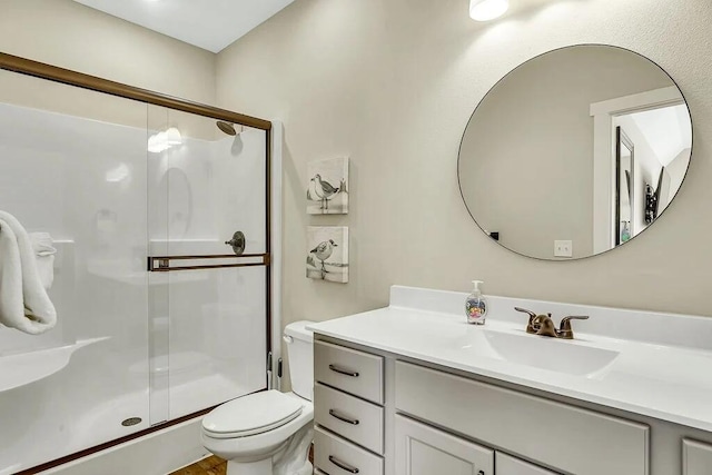 bathroom with an enclosed shower, vanity, and toilet