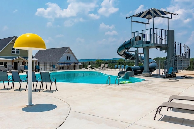 view of pool with a water slide and a patio area