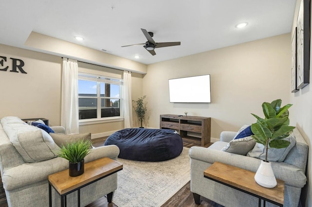 living room featuring dark wood-type flooring and ceiling fan