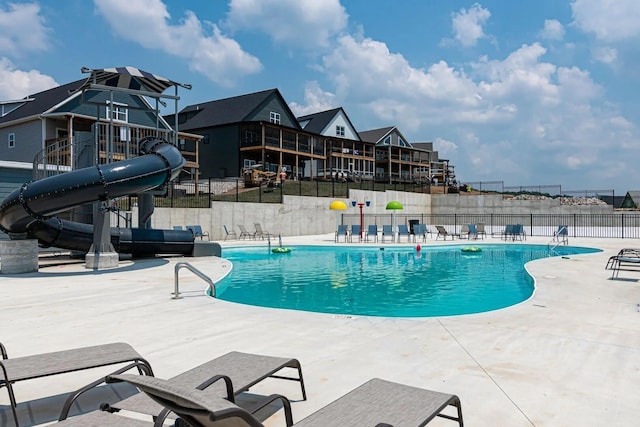 view of swimming pool featuring a water slide and a patio area