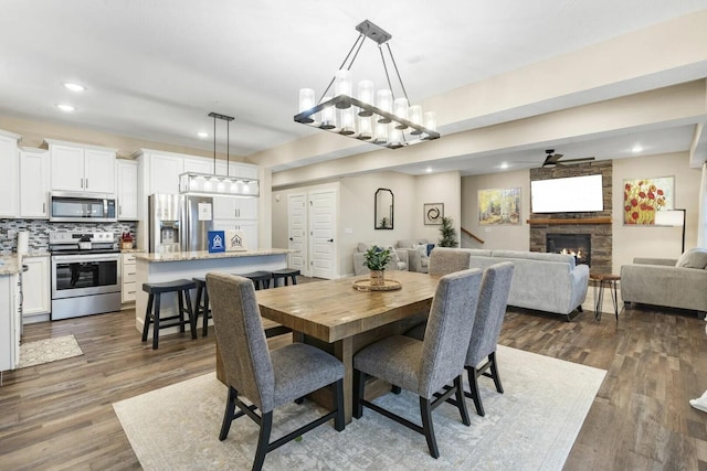 dining area featuring a fireplace and dark wood-type flooring