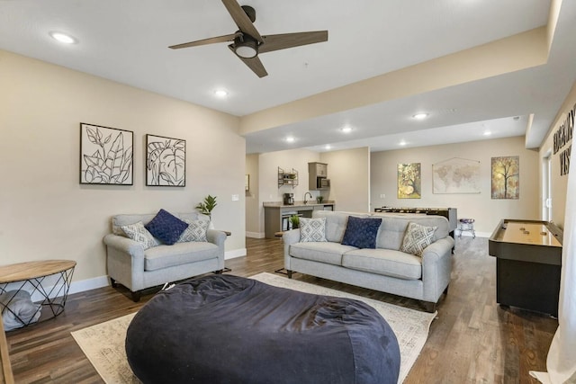 living room with dark hardwood / wood-style floors, sink, and ceiling fan