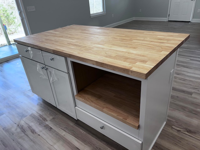 kitchen featuring wood counters, dark hardwood / wood-style floors, and white cabinets