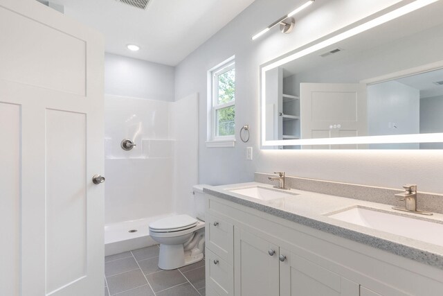 bathroom with vanity, a shower, tile patterned flooring, and toilet