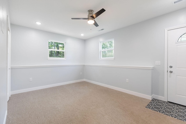 empty room featuring ceiling fan and light colored carpet