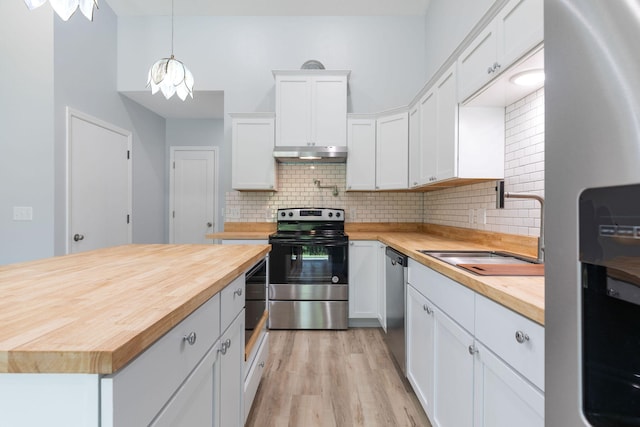 kitchen featuring pendant lighting, sink, white cabinetry, stainless steel appliances, and butcher block counters