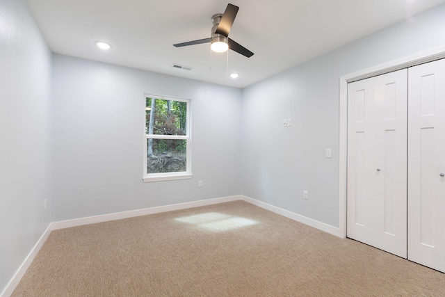 unfurnished bedroom featuring a closet, light carpet, and ceiling fan