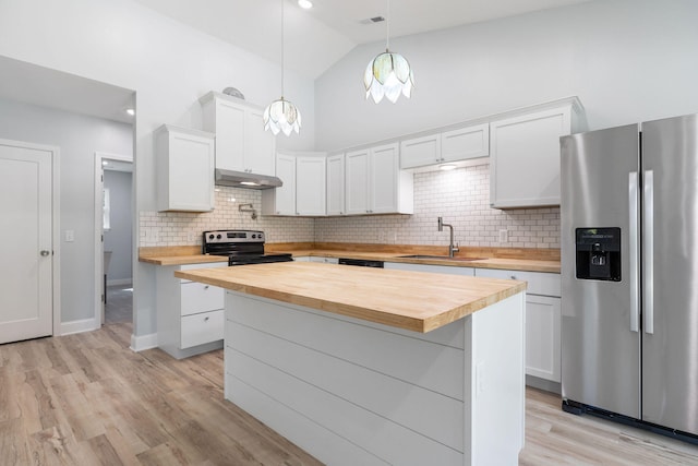 kitchen with butcher block countertops, hanging light fixtures, appliances with stainless steel finishes, and white cabinets