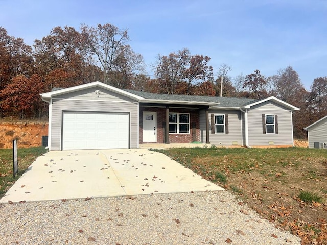 single story home with driveway, brick siding, and a garage