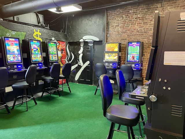 playroom featuring carpet floors, a towering ceiling, and brick wall