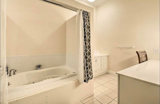 bathroom with tile patterned flooring, a tub to relax in, and vanity