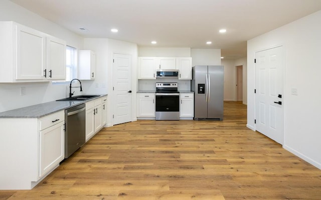 kitchen featuring light hardwood / wood-style floors, sink, white cabinetry, and stainless steel appliances