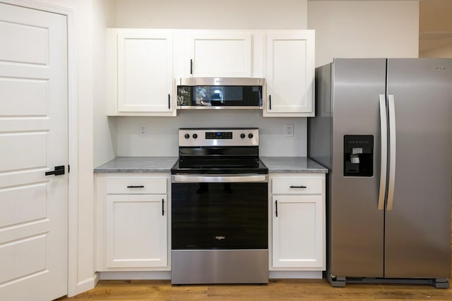 kitchen featuring white cabinets, stainless steel appliances, and light hardwood / wood-style flooring