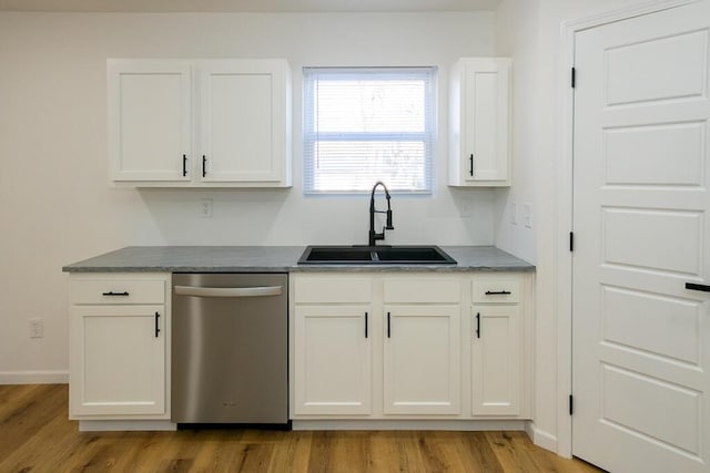 kitchen featuring light wood-type flooring, white cabinetry, stainless steel dishwasher, and sink