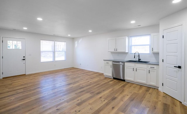 kitchen with light hardwood / wood-style flooring, white cabinetry, a wealth of natural light, and stainless steel dishwasher