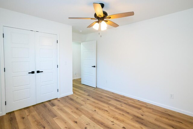 unfurnished bedroom featuring ceiling fan, a closet, and light hardwood / wood-style floors