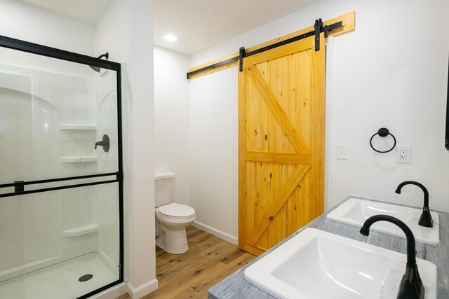 bathroom featuring toilet, hardwood / wood-style floors, an enclosed shower, and sink