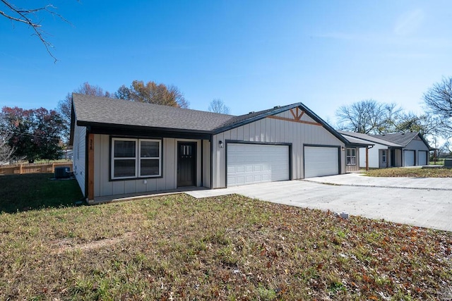 ranch-style home featuring a garage, central air condition unit, and a front lawn