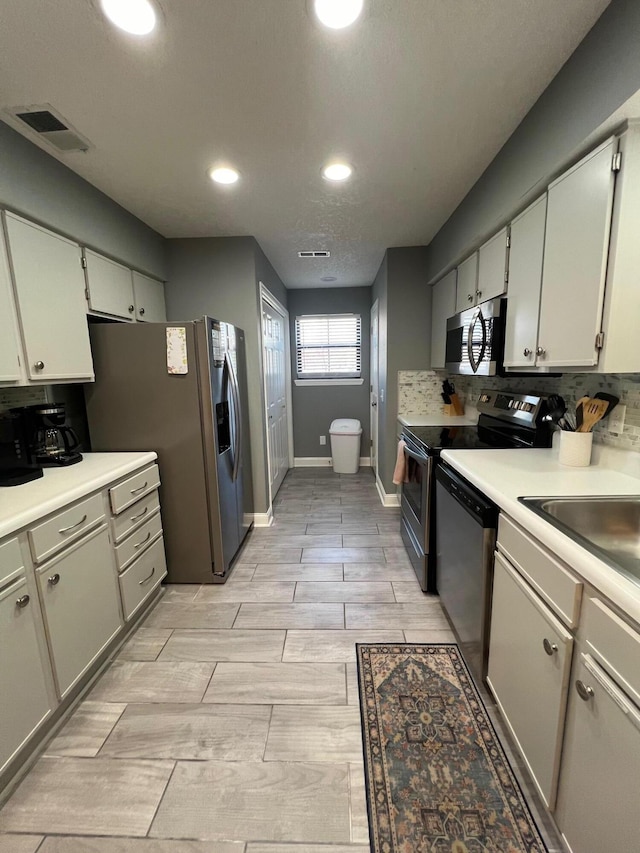 kitchen featuring backsplash, appliances with stainless steel finishes, and light wood-type flooring