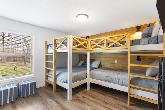 bedroom with wood-type flooring and wooden walls