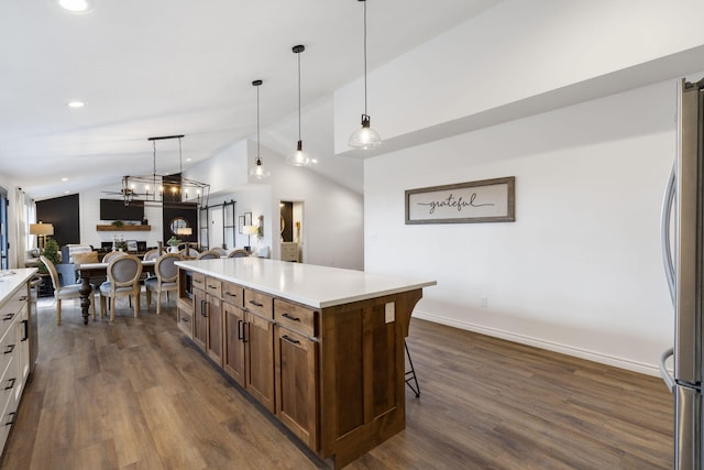 kitchen featuring dark wood-type flooring, hanging light fixtures, and vaulted ceiling