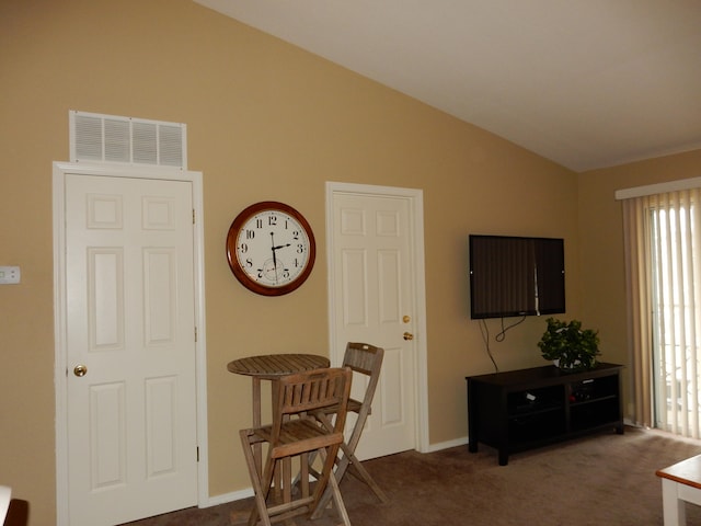 interior space with lofted ceiling and dark carpet