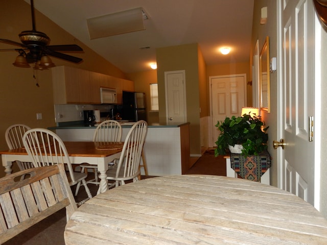 dining space featuring ceiling fan and vaulted ceiling