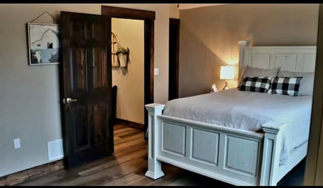 bedroom with dark hardwood / wood-style floors