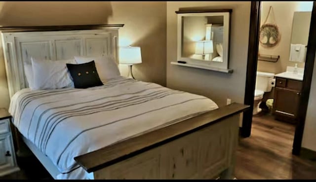 bedroom with ensuite bathroom and dark hardwood / wood-style flooring