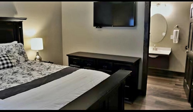 bedroom featuring hardwood / wood-style flooring and sink