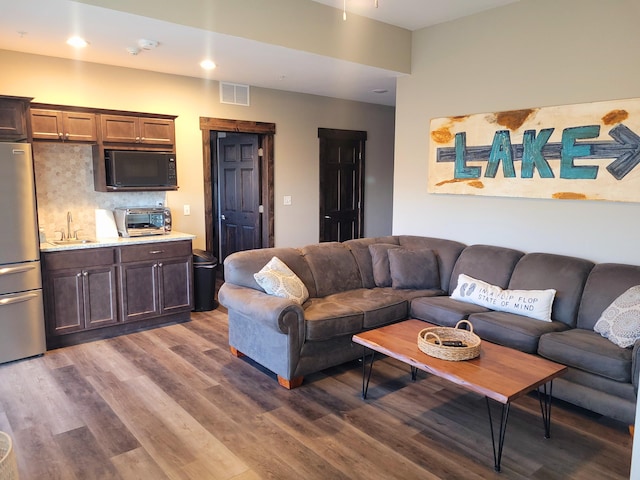 living room featuring sink and dark hardwood / wood-style floors