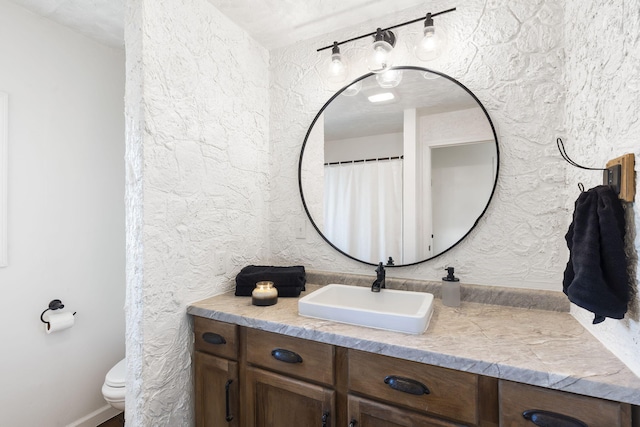 bathroom with vanity, a textured ceiling, and toilet