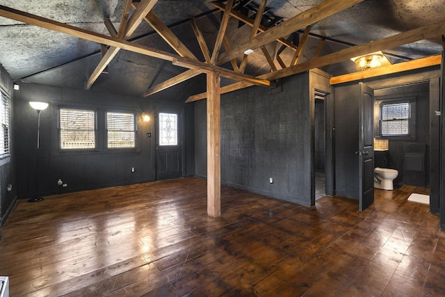 basement featuring wooden walls and dark hardwood / wood-style flooring