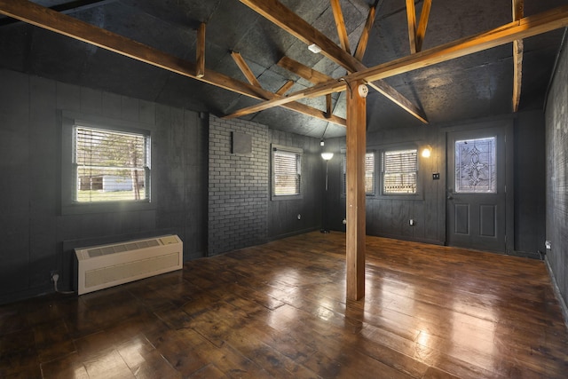 foyer entrance featuring an AC wall unit, vaulted ceiling with beams, dark hardwood / wood-style floors, and wood walls