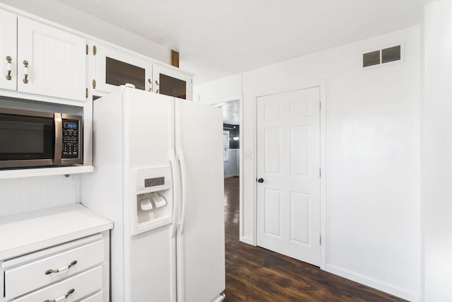 kitchen with white fridge with ice dispenser, white cabinets, and dark hardwood / wood-style flooring