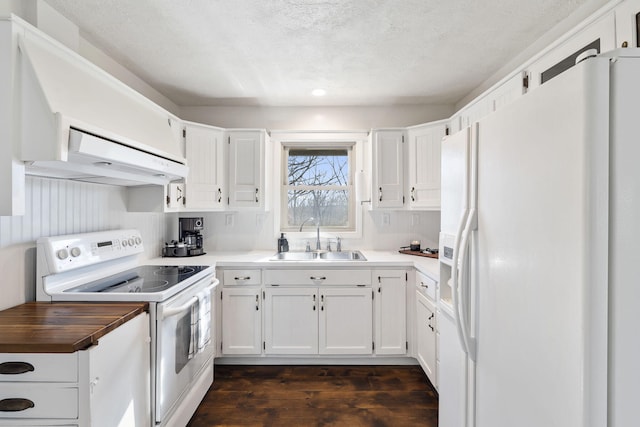 kitchen with sink, white cabinets, dark hardwood / wood-style floors, and white appliances