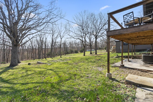 view of yard with a deck and central AC unit