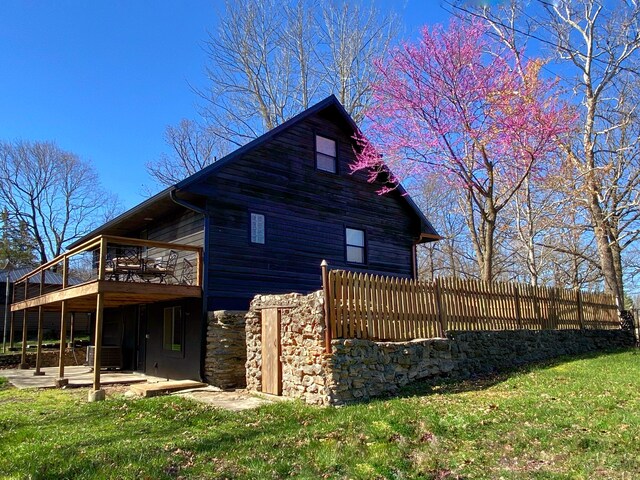 view of side of property with a patio and a lawn