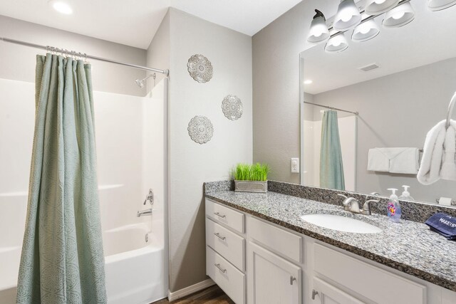 bathroom with hardwood / wood-style floors, shower / bath combo with shower curtain, and vanity