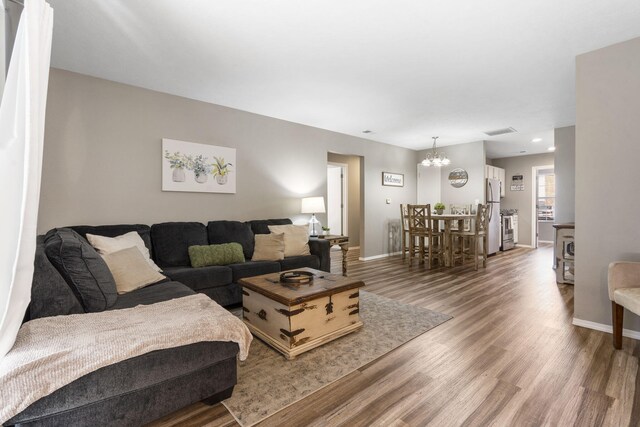 living room featuring a notable chandelier and hardwood / wood-style flooring